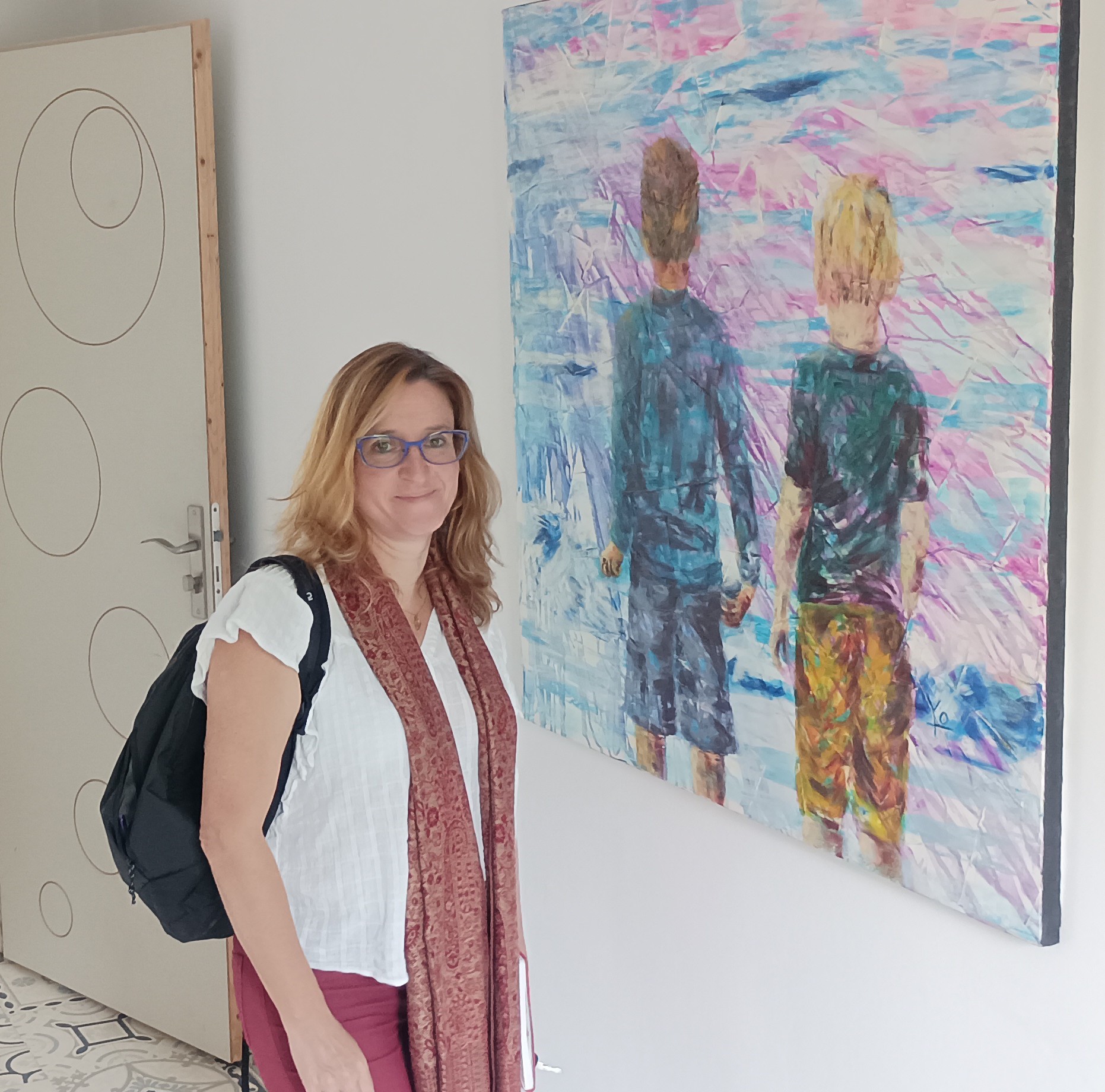 Yolaine, artiste peintre, à côté de l'un de ses tableaux